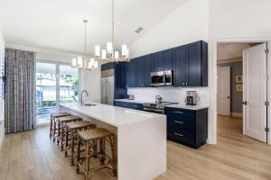 a kitchen with blue cabinets and a kitchen island with bar stools at Tuscan Vacation Rental in Naples