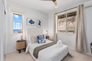 @Marbella Lane-Pōmaika'i LoveNest Ocean+MT View في Waianae: غرفة نوم بيضاء بها سرير ونافذة