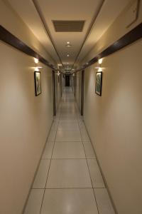 um corredor com um longo corredor com paredes brancas em Sree Sakthi Residency em Kanchipuram