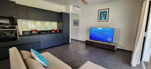 - un salon avec un canapé et une télévision dans l'établissement Suite Vai Tea, à Paea