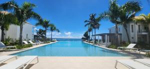 - une piscine bordée de chaises et de palmiers dans l'établissement Suite Vai Tea, à Paea