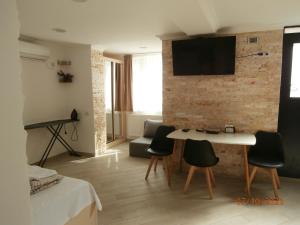 a living room with a table and chairs and a tv on a brick wall at "Vera old City" in Tbilisi City