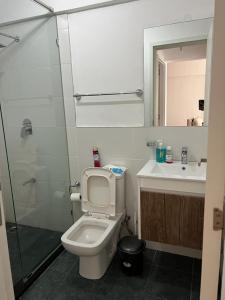 a bathroom with a toilet and a sink and a shower at Cosyplace at Mi Vida in Garden city in Nairobi