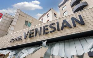 a sign for a jumeirah hotel in front of a building at Hotel Venesian in Pohang