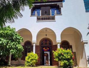 a building with arches and a window and flowers at Riad Tazi Casablanca in Casablanca