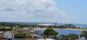 arial view of a building and a beach with a church at Residencial Oliveira - Charmoso e Aconchegante in Itacaré