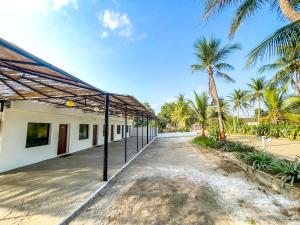 an empty building with palm trees in the background at Stay Guru Resort Farm Villa in Bhuj