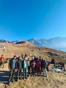 a group of people standing on top of a mountain at Triund Trek in Dharamshala +6 photos