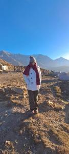 a young child standing on a rocky field at Triund Trek in Dharamshala
