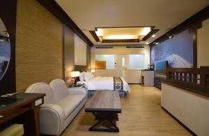 um quarto de hotel com uma cama e um sofá em Summer House Motel em Tainan
