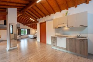 リポストにあるAgriturismo dell'Etnaの白いキャビネットと木製の天井が備わるキッチン