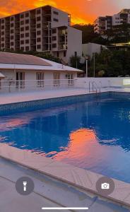 ein großer Pool mit Sonnenuntergang im Hintergrund in der Unterkunft Civic Guesthouse in Townsville