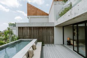 an external view of a house with a swimming pool at The Komu in Canggu