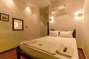 um pequeno quarto com uma cama com toalhas em The French Villa em Pondicherry