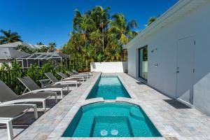 an outdoor swimming pool with chairs and a swimming poolvisor at Sorrento Vacation Rental in Naples