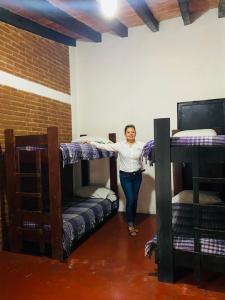 a woman standing in a room with two bunk beds at Club Santa Maria in Cuernavaca