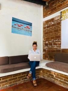 a woman sitting on a couch with a laptop at Club Santa Maria in Cuernavaca
