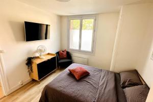 um quarto com uma cama, uma televisão e uma cadeira em Appartement 3 chambres + parking à Lyon 7 em Lyon