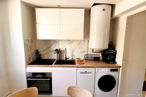 uma cozinha com armários brancos e uma máquina de lavar e secar roupa em Appartement 3 chambres + parking à Lyon 7 em Lyon