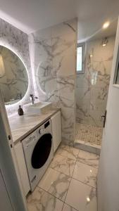 uma casa de banho branca com um lavatório e um chuveiro em Appartement 3 chambres + parking à Lyon 7 em Lyon