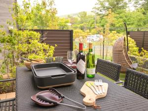 a table with two bottles of wine and a pan on it at Rakuten STAY VILLA Lake Yamanakako 105 View bath Mt Fuji View in Yamanakako