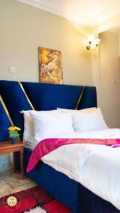 a bed with a blue headboard in a room at Empire du Luxe in Yaoundé