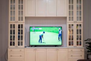 a tv screen with two golf players on a golf course at Relaxing 5B2BHome w Parking Walk to Brisbane River in Brisbane