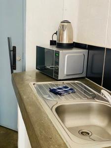 a microwave sitting on top of a counter next to a sink at Views on main: Craftsmanship hotel in Johannesburg