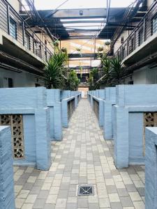 a hallway in a building with blue columns and plants at Views on main: Craftsmanship hotel in Johannesburg