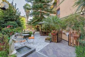 a patio with a table and chairs and trees at Guest House Il Limone Nascosto in Rome