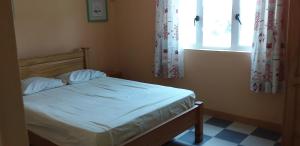um pequeno quarto com uma cama com janela em Flamengo em Pereybere