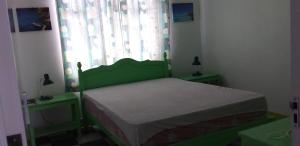 a small bedroom with a green bed and a window at Flamengo in Pereybere