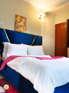 a large bed with a blue headboard in a room at Empire du Luxe in Yaoundé