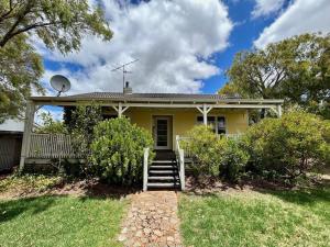 una casa amarilla con escaleras delante en The Happy Home – a classic Margs Experience en Margaret River Town