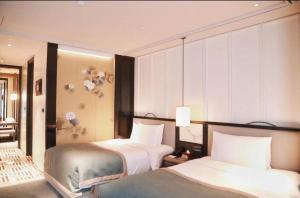 a hotel room with two beds in a room at JiuTai Hotel Hangzhou in Hangzhou
