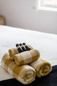una pila de cuatro controles remotos sentados sobre una toalla en The Happy Home – a classic Margs Experience en Margaret River