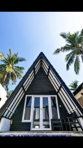 a house with a window and a palm tree at Resort Gili Trawangan in Gili Trawangan