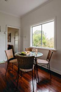 comedor con mesa, sillas y ventana en The Happy Home – a classic Margs Experience en Margaret River Town