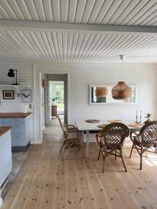 uma cozinha e sala de jantar com mesa e cadeiras em Bright And Cozy Summer Cottage On A Secluded Plot em Kerteminde