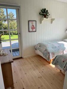 uma sala com um quarto com uma cama e uma porta em Bright And Cozy Summer Cottage On A Secluded Plot em Kerteminde