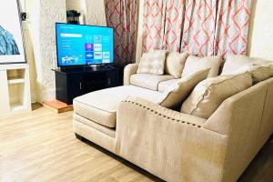 a living room with a couch and a flat screen tv at Beautiful Spanish-Styled Home in Fresno