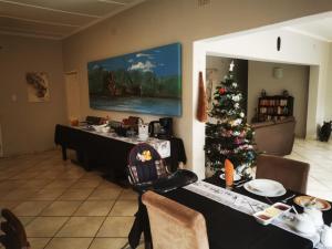 uma sala de jantar com uma árvore de Natal e uma mesa em Parkers Cottages em St. Lucia