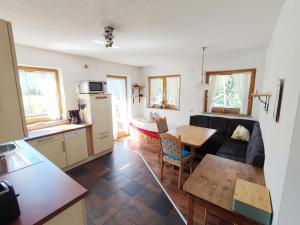 een keuken en een woonkamer met een bank en een tafel bij Scenic Holiday Home in Ramsau with Garden Barbeque in Hippach