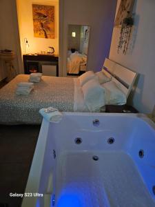 a bathroom with a bath tub next to a bed at B&B Napoli Centrale Room&Jacuzzi in Naples