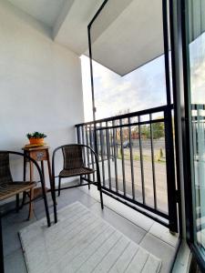 a balcony with two chairs and a table and a window at River park CB in Reghin