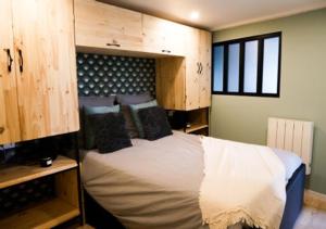 una camera da letto con un letto con testiera in legno di Le Gîte d’Élisabeth a Doulezon