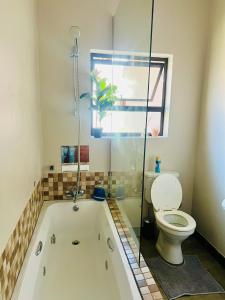 uma casa de banho com banheira e WC em Luxury@Groendal close em Nelspruit