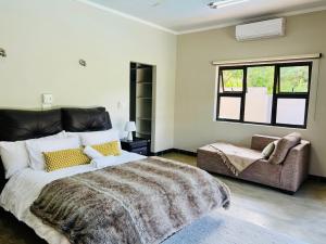 um quarto com uma cama grande e um sofá em Luxury@Groendal close em Nelspruit