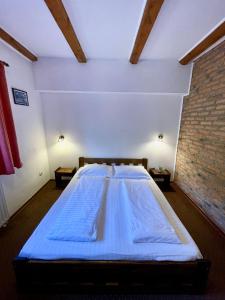 un grande letto in una stanza con muro di mattoni di Resort 7 Crai - Cabana Craiul Crailor a Zărneşti