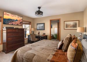 a bedroom with a bed with a dresser and a desk at Mountain View Home on 2 Acres in Bozeman